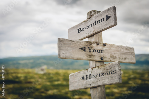 broaden your horizons text quote written in wooden signpost outdoors in nature. Moody theme feeling. photo