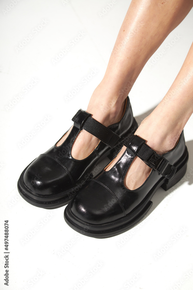 Naklejka premium Beautiful woman legs in black shoes. Studio shot on white background