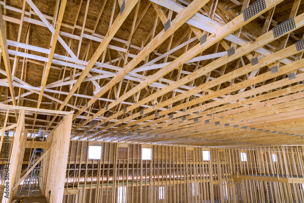 Interior framing of a new house under construction with roof truss system beams built frame