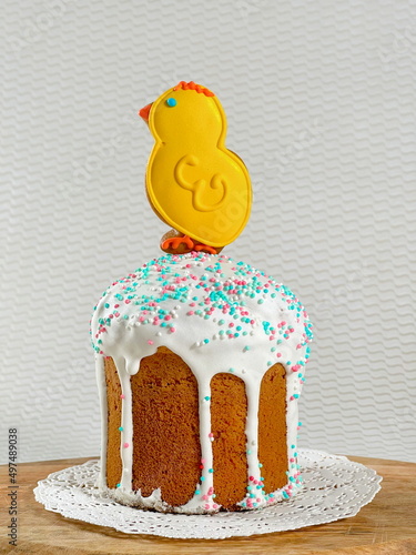 Traditional Easter cake on a lace napkin on a wooden board on a white table on a white background. photo