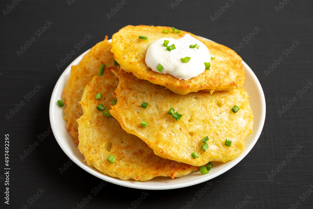 Homemade Boxty Irish Potato Pancakes on a Plate on a black background, side view. Homemade Boxty Irish Potato Pancakes on a Plate on a black background, side view.