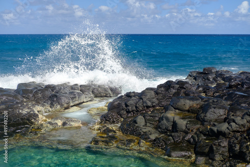 Waves splashing against lava rock tidal pool shore