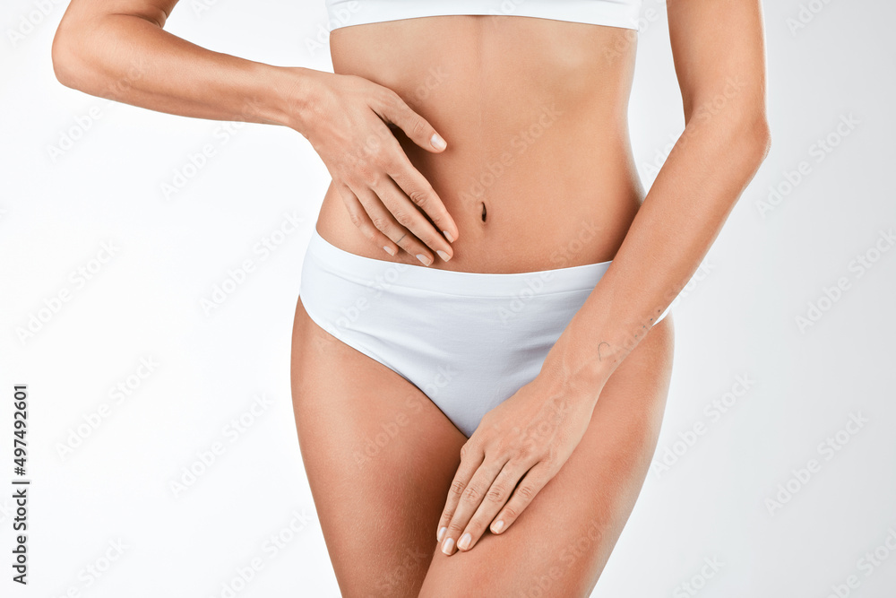 Maintaining a healthy gut microbiome. Shot of a woman touching her stomach against a studio background.