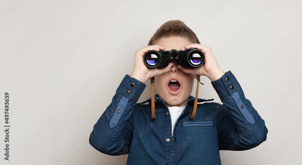 The boy makes observations looking through binoculars The boy makes observations looking through binoculars