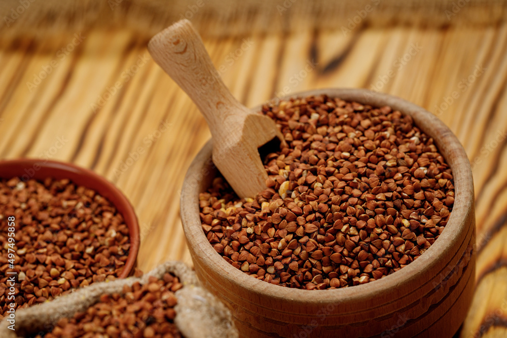 Buckwheat groats in bowls and bags on a wooden background. High quality photo Buckwheat groats in bowls and bags on a wooden background. High quality photo