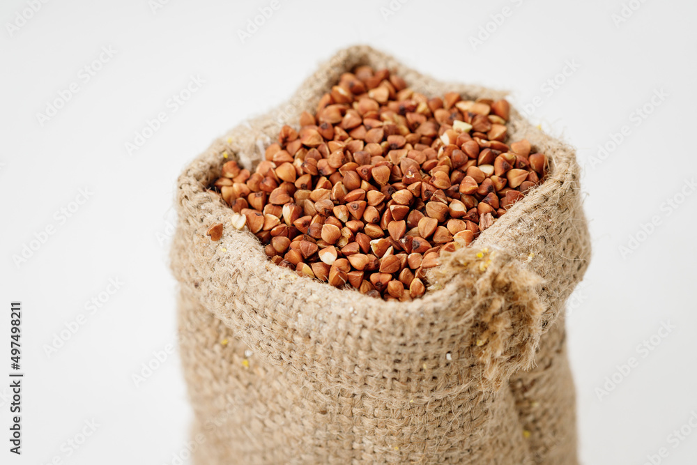 Buckwheat groats in bowls and bags isolated on a white background. High quality photo Buckwheat groats in bowls and bags isolated on a white background. High quality photo