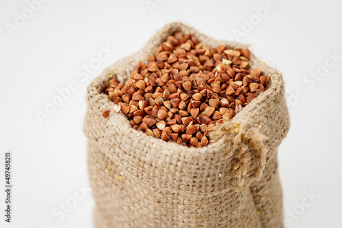 Buckwheat groats in bowls and bags isolated on a white background. High quality photo © bondvit