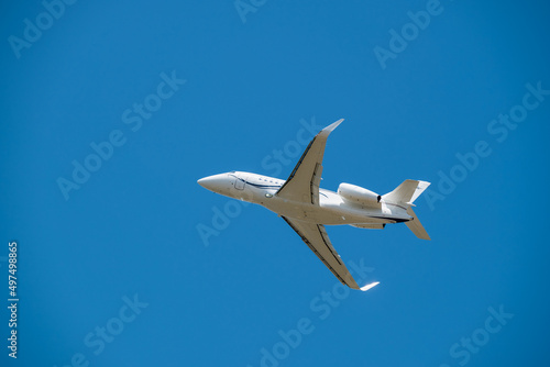 White Jet Airplane Taking Off Overhead Blue Sky