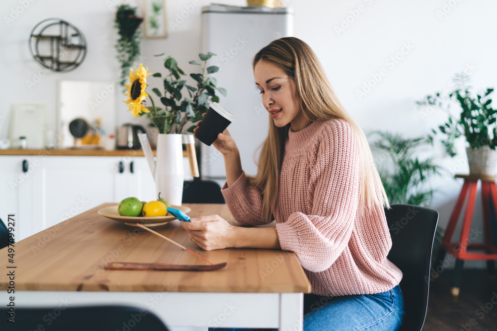 Girl using smartphone and drinking coffee at home Girl using smartphone and drinking coffee at home