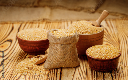Wheat groats in bowls and bags on a wooden background. High quality photo