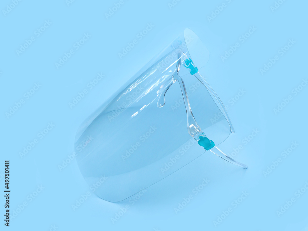 Face shield or protective isolation mask on a blue background. Face shield or protective isolation mask on a blue background.