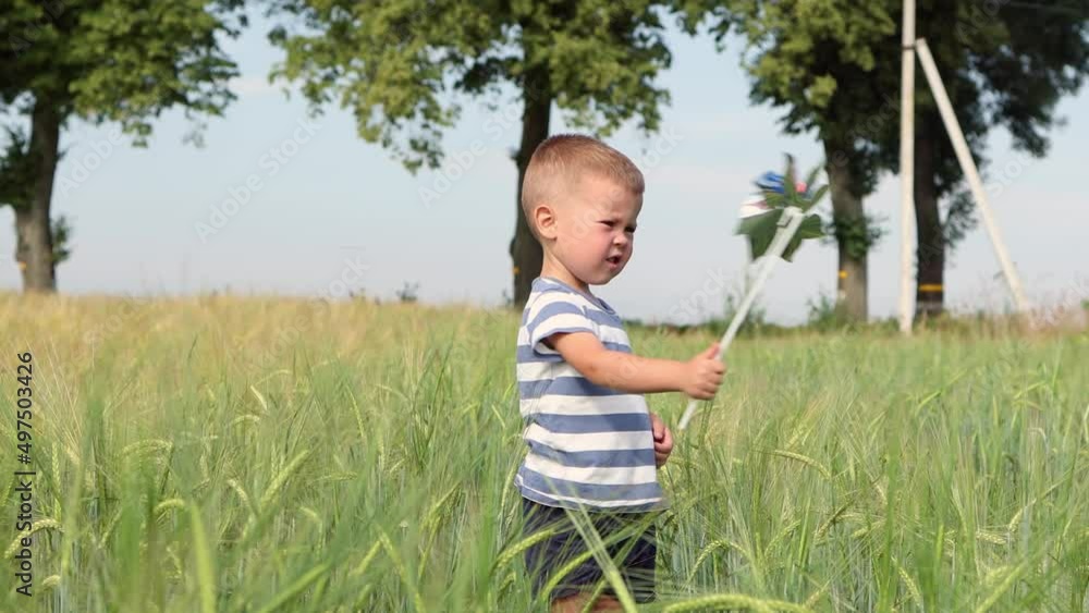 child boy kid playing with windmill pinwheel outdoors in green wheat field, celebrating usa Independence Day of America, 4th July holiday, pinwheel colors of usa flag, red blue Stars and Stripes child boy kid playing with windmill pinwheel outdoors in green wheat field, celebrating usa Independence Day of America, 4th July holiday, pinwheel colors of usa flag, red blue Stars and Stripes