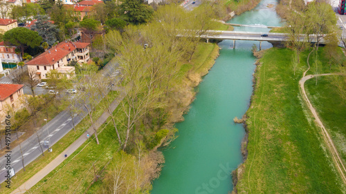 Aerial view of a bridge on the Santerno river near Imola, Italy. On the sides there is the park of the Imola riverside.