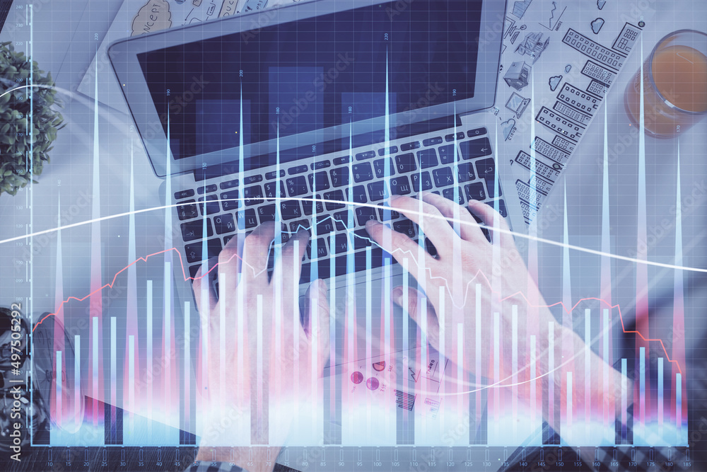 Double exposure of man's hands typing over laptop keyboard and forex chart hologram drawing. Top view. Financial markets concept. Double exposure of man's hands typing over laptop keyboard and forex chart hologram drawing. Top view. Financial markets concept.