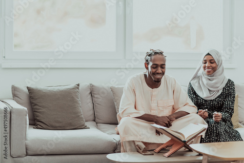 African Muslim couple at home in Ramadan reading Quran holly Islam book.