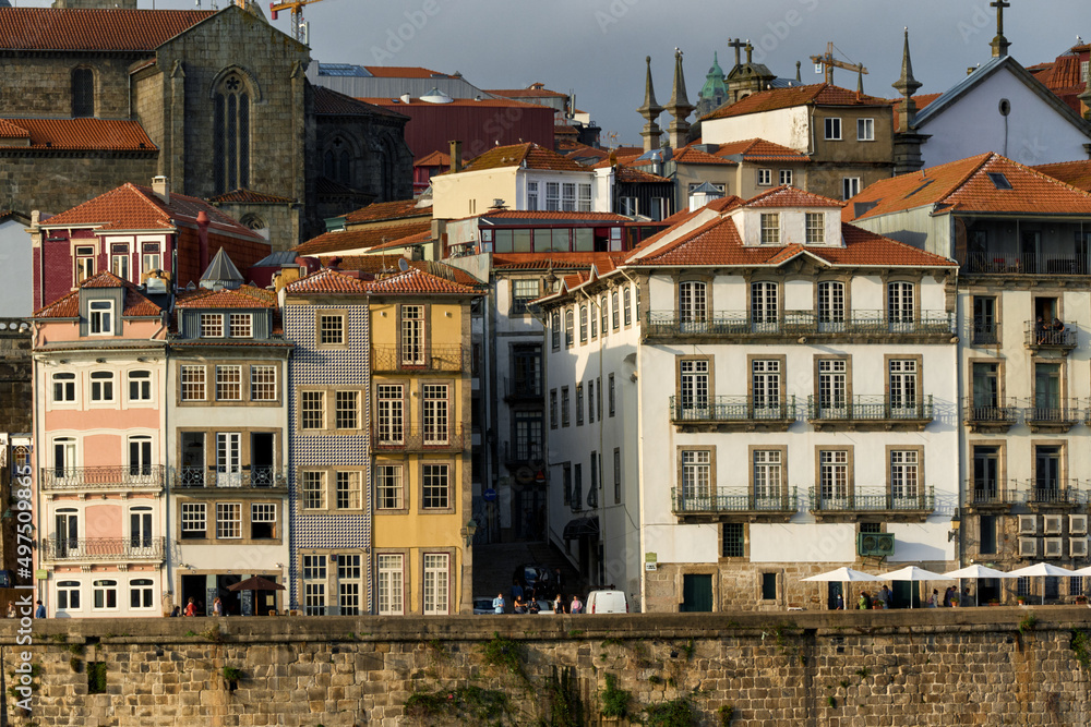 Colorful houses and traditional facades with red roof tiles on the embankment of Ribeira district in Porto, Portugal

