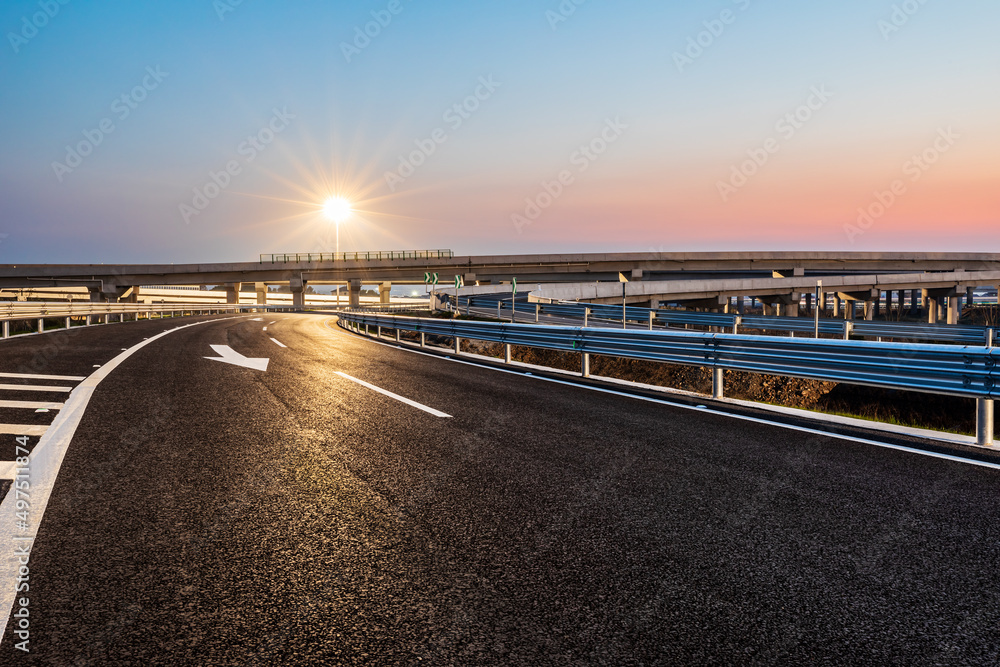 Empty asphalt highway and street lights with beautiful sky at sunset Empty asphalt highway and street lights with beautiful sky at sunset