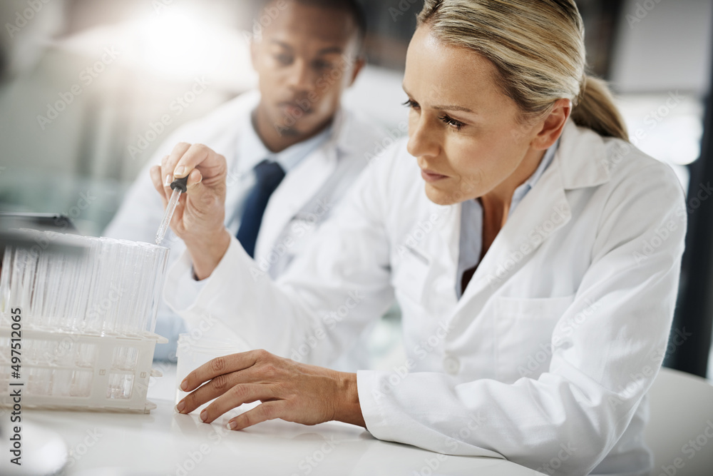 Lets test these samples. Cropped shot of two scientists testing a sample while doing research in their lab. Lets test these samples. Cropped shot of two scientists testing a sample while doing research in their lab.