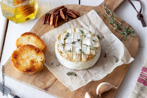 Baked Camembert cheese with garlic, thyme and toasted bread. French cuisine.