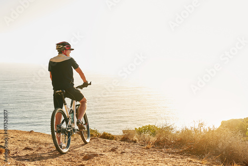No bucket list but my bikeit list is a mile long. Shot of a man admiring the view from a hilltop while out on a bike ride.