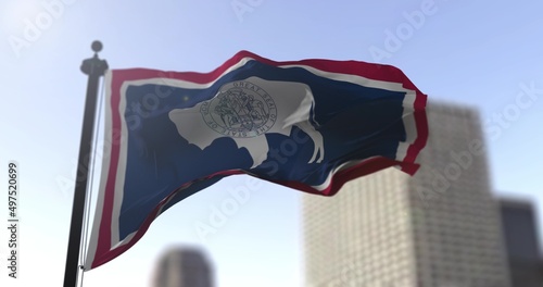 Wyoming state waving flag on blurry background, USA state news illustration. Blurry background
