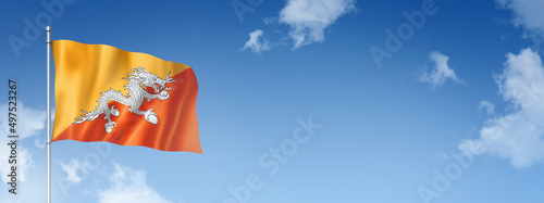 Bhutan flag isolated on a blue sky. Horizontal banner photo