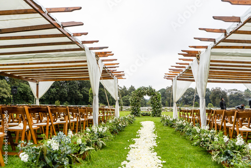 Outdoor wedding venue with a flower petal aisle on a field