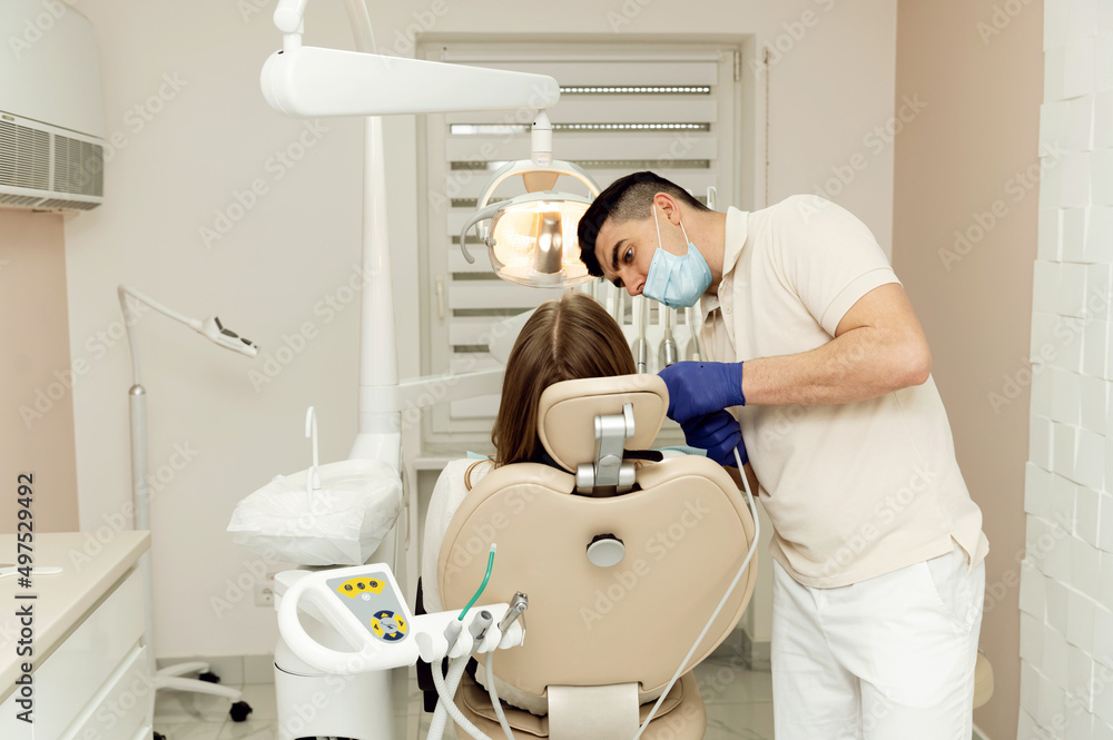 dental treatment process. the dentist holds the tools in his hands and examines the teeth. patient at the dentist. dental office. dental treatment process. the dentist holds the tools in his hands and examines the teeth. patient at the dentist. dental office.