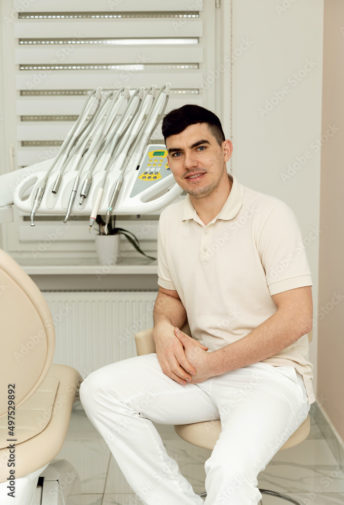 young doctor dentist is in the dental office. highly qualified dentist. portrait of a doctor in the workplace. dental office young doctor dentist is in the dental office. highly qualified dentist. portrait of a doctor in the workplace. dental office