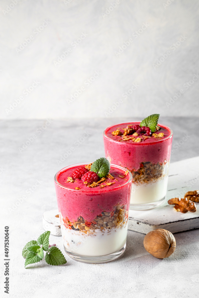 Yogurt, raspberry smoothie and homemade granola in a transparent glass. Healthy breakfast or snack. Copy space Yogurt, raspberry smoothie and homemade granola in a transparent glass. Healthy breakfast or snack. Copy space