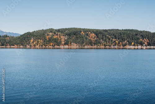 Photo of blue lake against forest hills photo