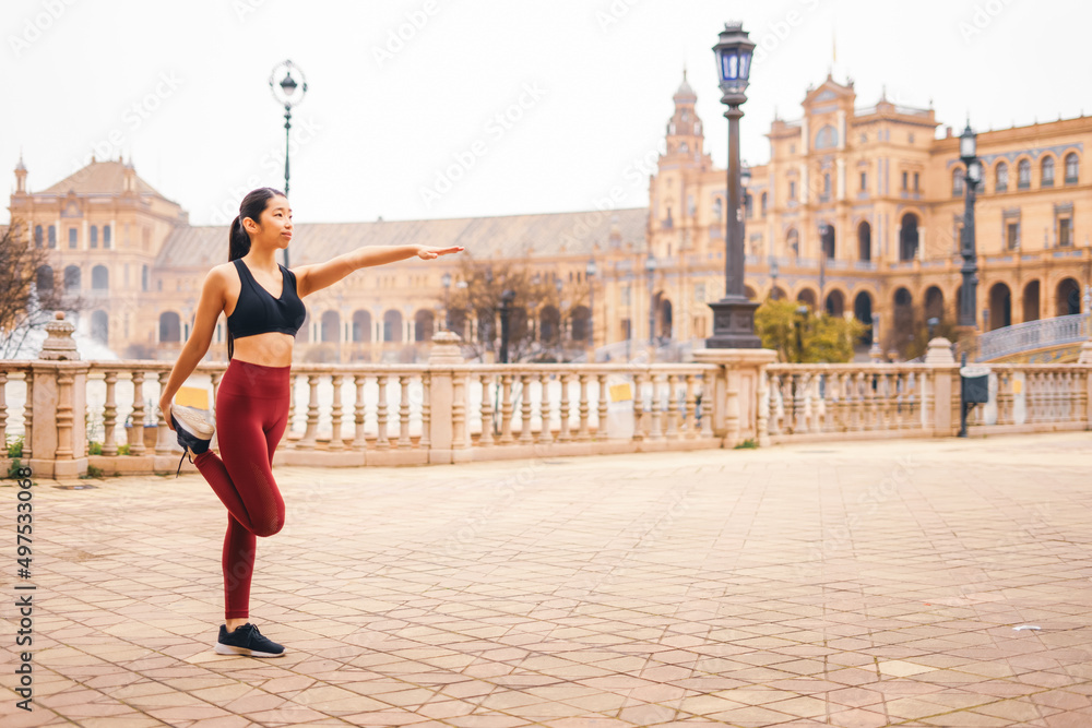Asian woman doing stretching exercise in the city