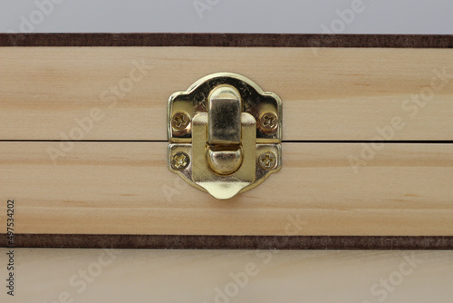 Closeup shot of golden a brass latch of a wooden box