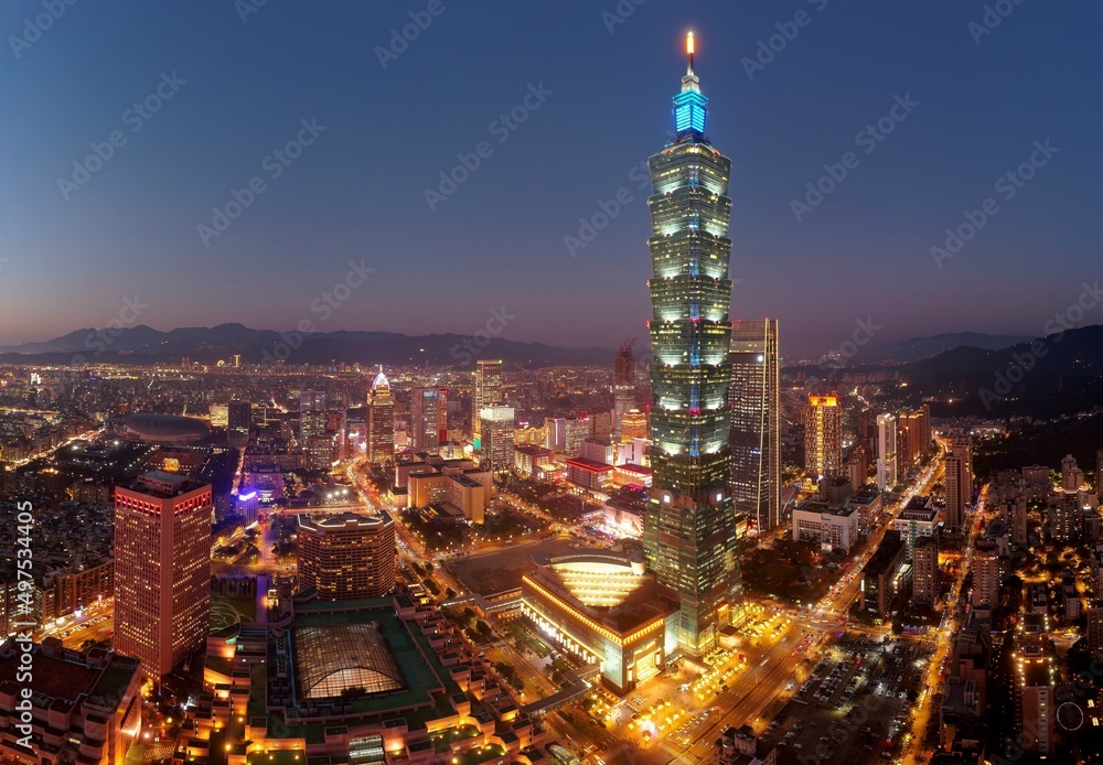 Fototapeta premium Aerial skyline of Downtown Taipei at dusk, vibrant capital city of Taiwan, with 101 Tower standing out amid skyscrapers in Xinyi Commercial District and oval shaped Taipei Dome located in nearby area
