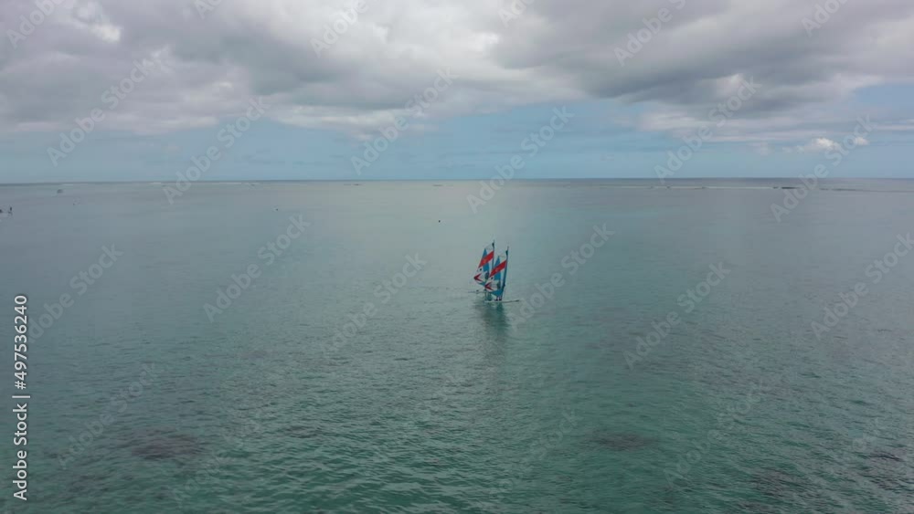 Aerial view of happy couple windsurf surfing in calm deep blue of Indian Ocean, extreme summer sport activity. Mauritius Aerial view of happy couple windsurf surfing in calm deep blue of Indian Ocean, extreme summer sport activity. Mauritius