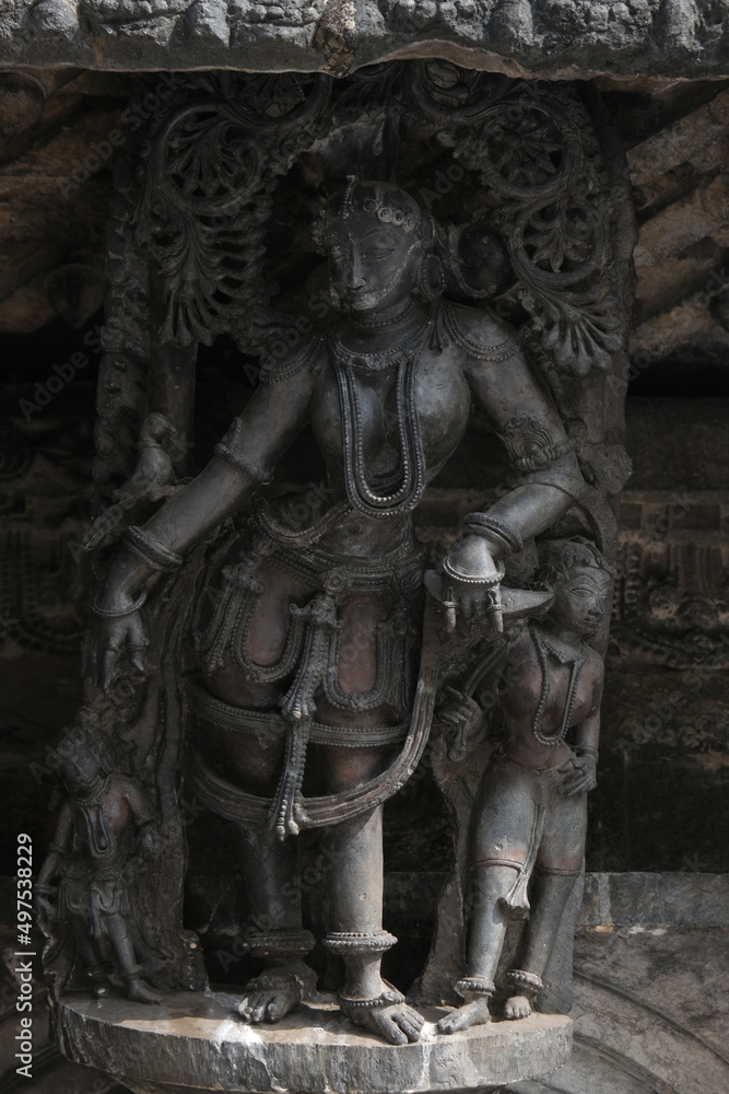 Obraz premium Stone Sculpture of Beautiful Female (Madanikas) with selective focus, 12th century Hindu temple, Ancient stone art and sculptures in each pillars, Chennakeshava Temple, Belur, Karnataka, India.