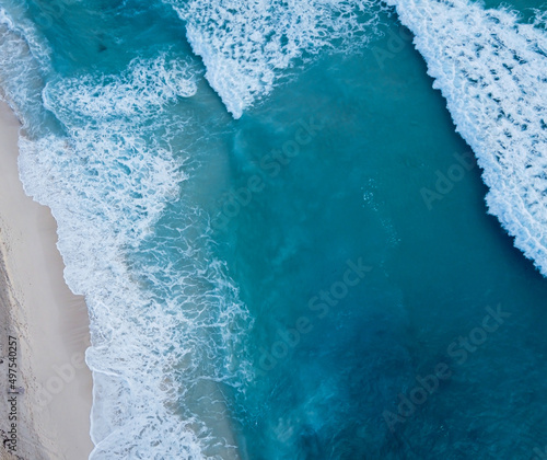 Aerial view to tropical beach and wave blue ocean at Cancun, Mexico. Aerial drone shot of turquoise sea water at the beach - space for text.