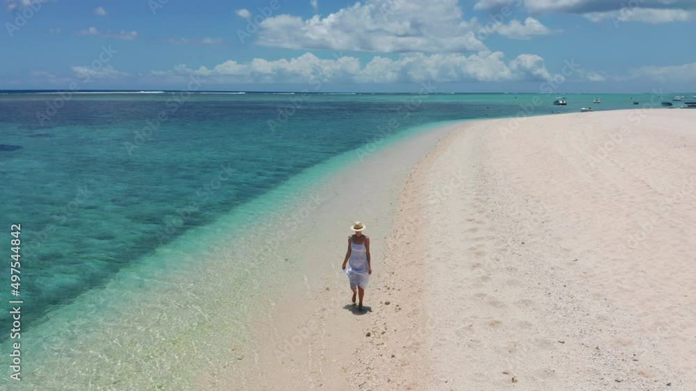Girl walking on a white sand beach on a tropical island in the Mauritius Indian ocean Girl walking on a white sand beach on a tropical island in the Mauritius Indian ocean