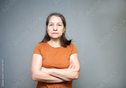 Elderly upset woman  on   gray background.
