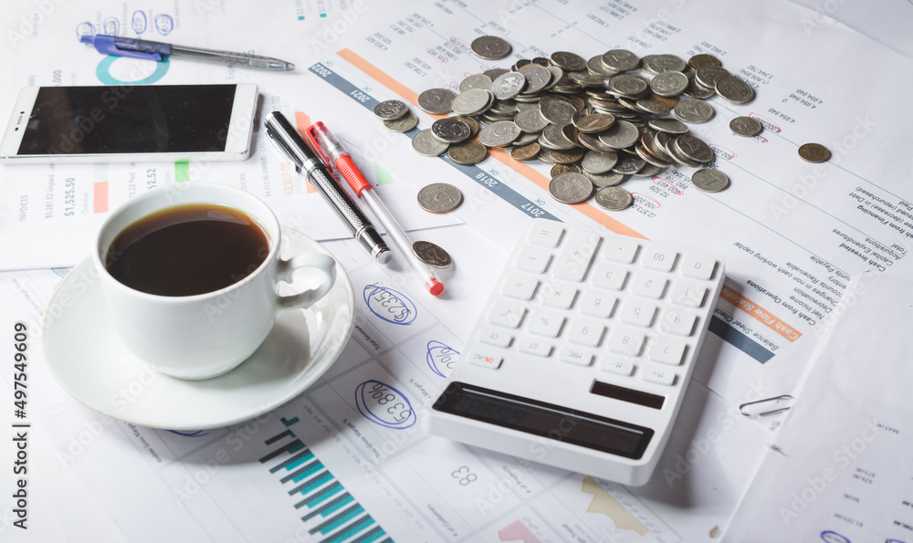 A cup of black coffee on an investor's desk with a financial report A cup of black coffee on an investor's desk with a financial report