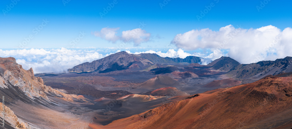 Panorama of dramatic clouds and the barren, colorful landscape of a volcanic crater at Haleakala National Park, Maui