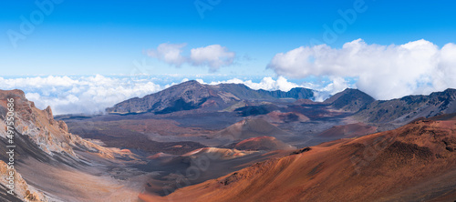 Panorama of dramatic clouds and the barren, colorful landscape of a volcanic crater at Haleakala National Park, Maui