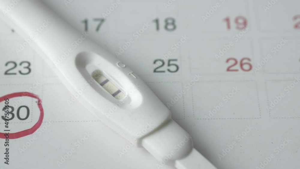 Pregnancy test kit on a calendar close up 