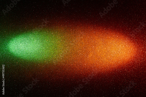 On a black background  a gradient green and orange beam of light