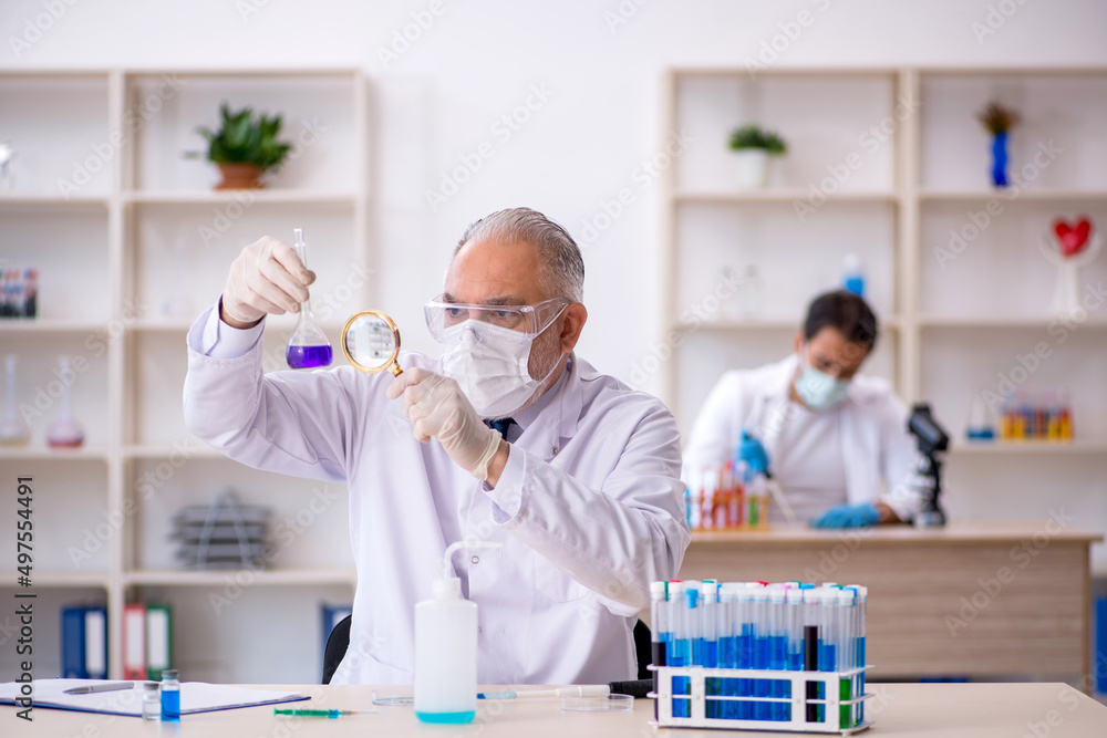 Two male chemist working at the lab Two male chemist working at the lab