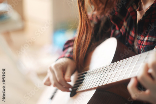Selective soft focus, close up hands teenager girl learning to play guitar. copy space