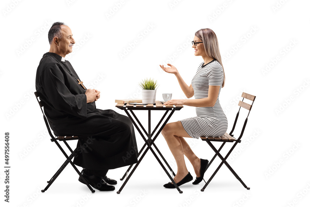 Obraz premium Priest and a young woman sitting at a cafe table and talking
