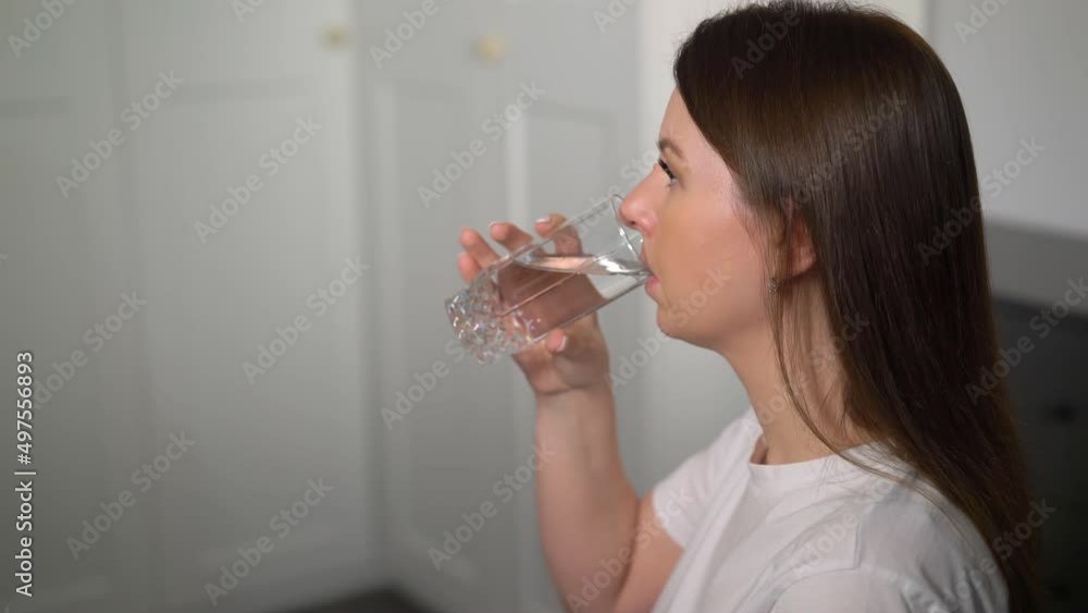 A young woman is taking pills. Blue vitamins, medicines in a blister pack. Health care, treatment. Illness, disease, sick person. Female hold dietary supplement in hands. Drink glass of water. A young woman is taking pills. Blue vitamins, medicines in a blister pack. Health care, treatment. Illness, disease, sick person. Female hold dietary supplement in hands. Drink glass of water.