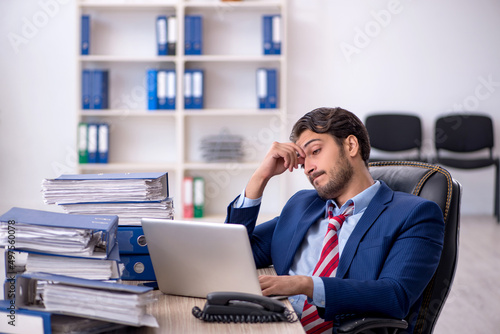 Young male employee and too much work in the office