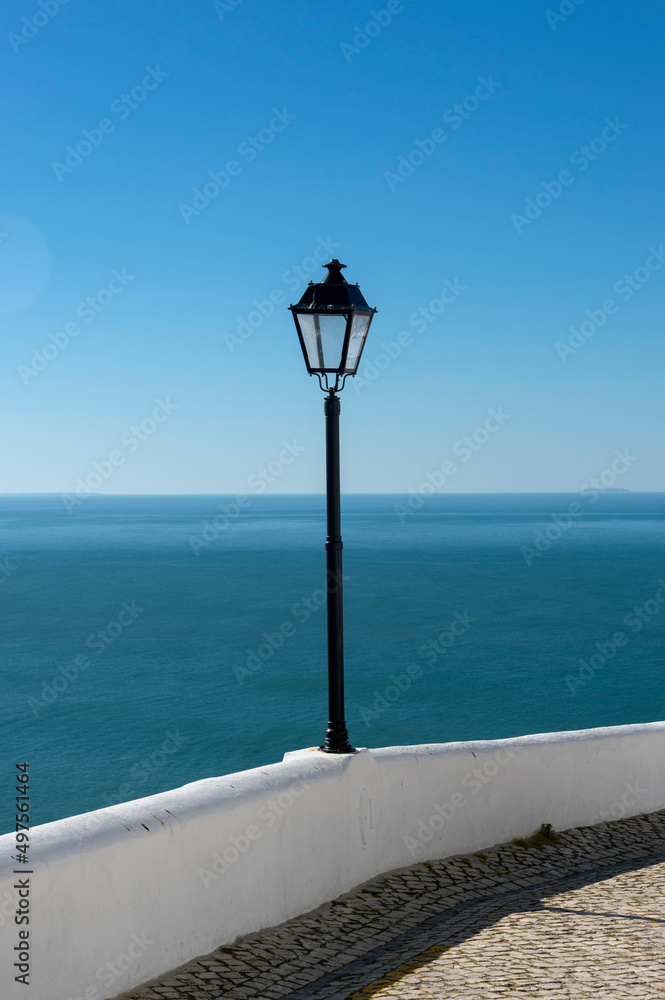 white wall and lamp post at viewing point at Sitio looking over Nazare, Portugal.